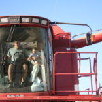 Historical photo of the Berger family in a Case combine during harvest