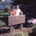 Historical photo of Ken and Ruth Berger at the homestead with Five Oak Farm sign