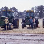 Historical photo of John Deer equipment lined up with operators